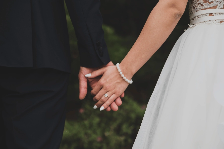 newly married couple holding hands outside after wedding ceremony